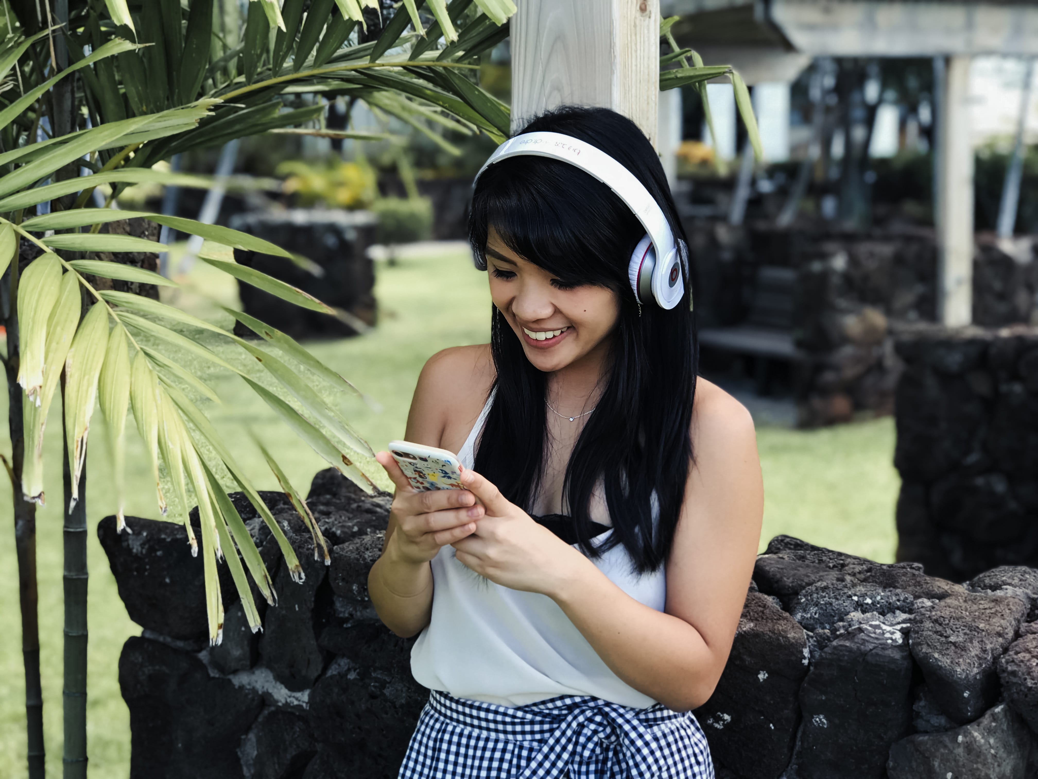 A girl looking at her device listening to a podcast